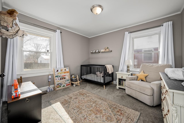 bedroom featuring a crib, dark colored carpet, crown molding, and multiple windows