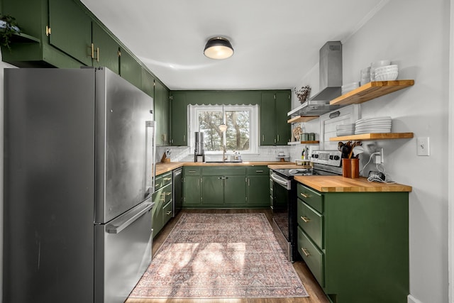 kitchen featuring wall chimney range hood, appliances with stainless steel finishes, and green cabinets