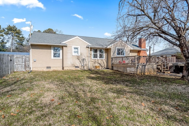 rear view of property featuring a wooden deck and a lawn