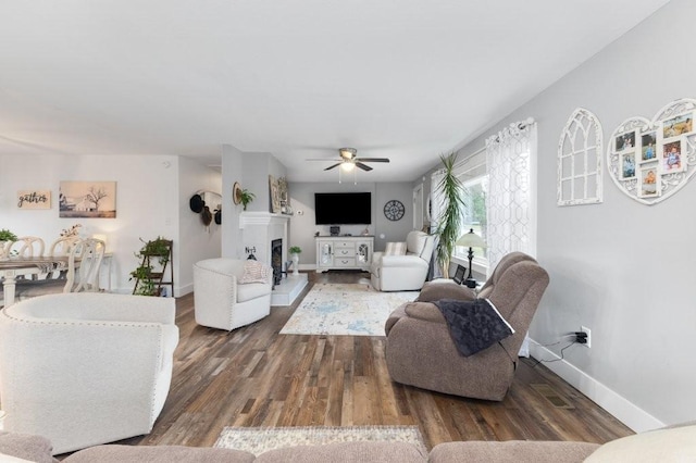 living room featuring dark wood-type flooring and ceiling fan