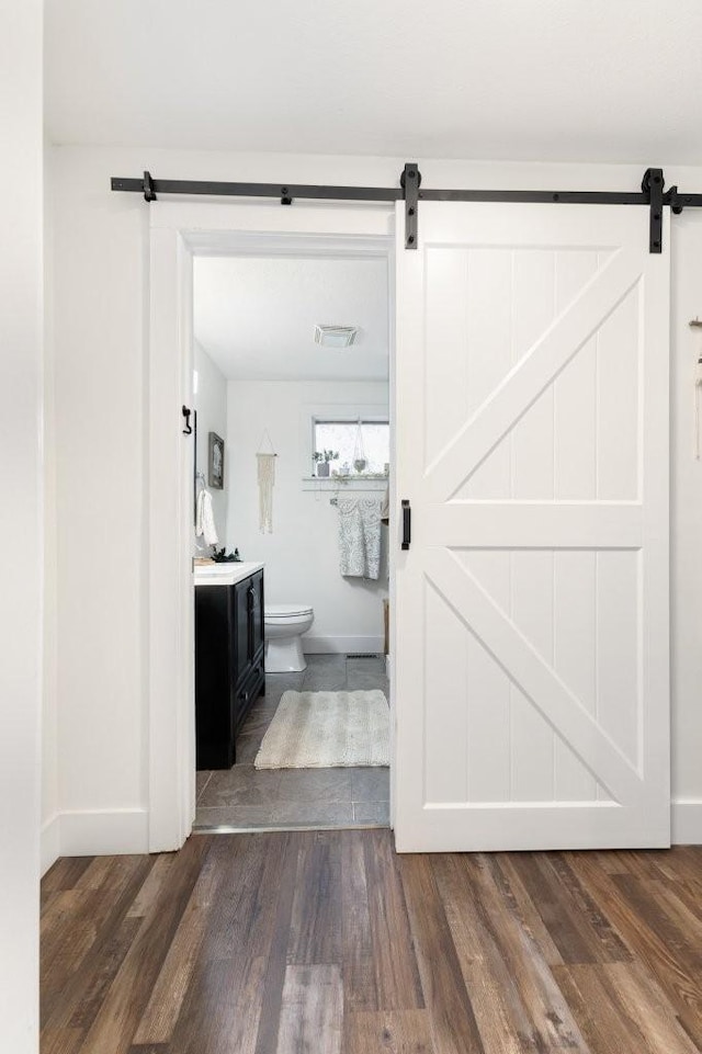 bathroom featuring vanity, wood-type flooring, and toilet