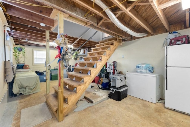 basement featuring white refrigerator and refrigerator