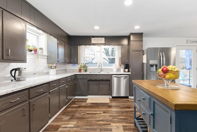 kitchen featuring sink, dark wood-type flooring, appliances with stainless steel finishes, butcher block counters, and tasteful backsplash