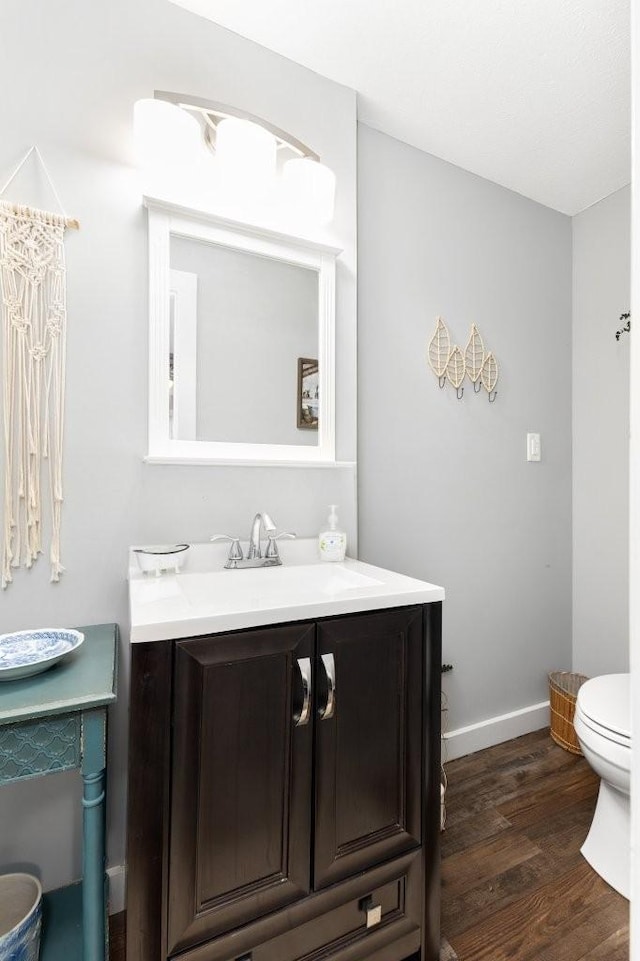 bathroom featuring vanity, hardwood / wood-style floors, and toilet