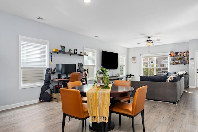 dining space with light hardwood / wood-style floors and ceiling fan