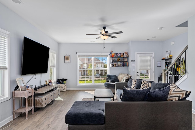 living room with light hardwood / wood-style floors and ceiling fan