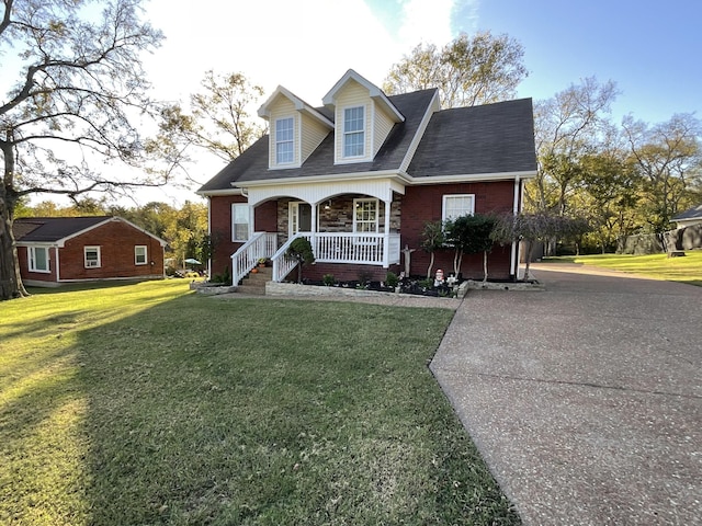 cape cod home with covered porch and a front lawn