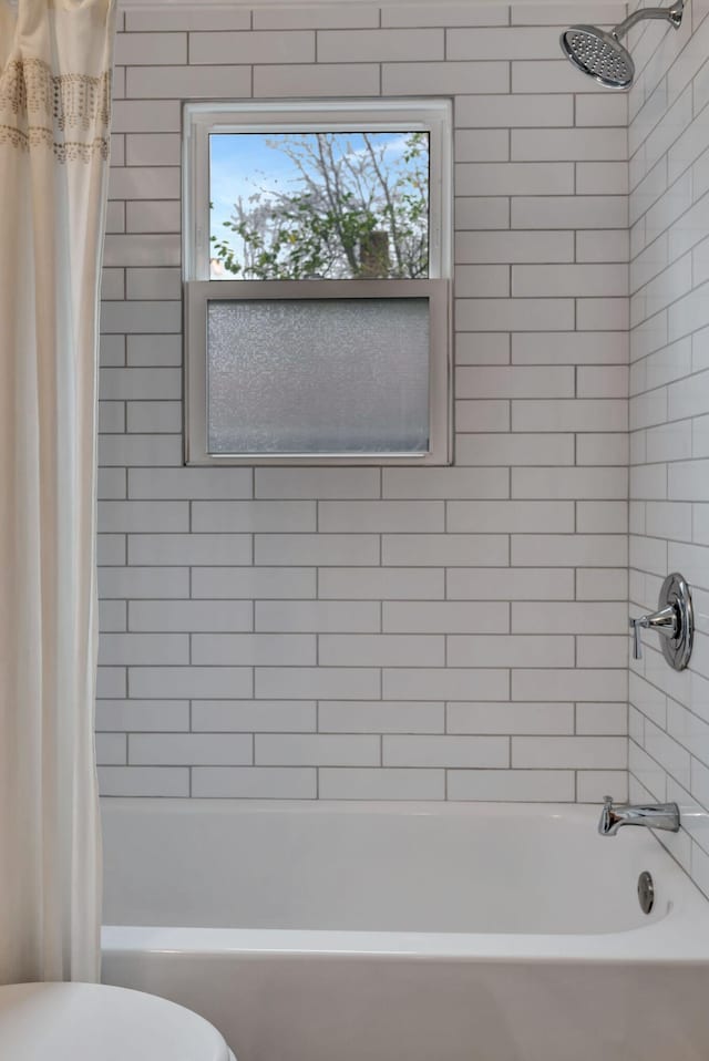 bathroom with toilet and shower / bath combo with shower curtain