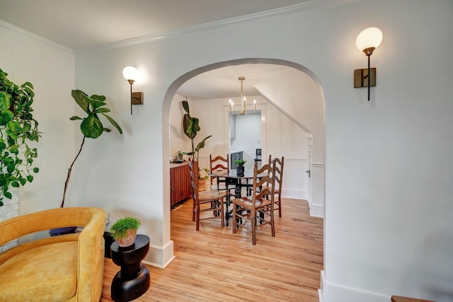 dining area featuring ornamental molding, a chandelier, and light hardwood / wood-style flooring