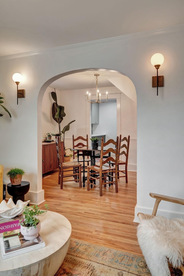 dining area featuring hardwood / wood-style flooring, crown molding, and a chandelier