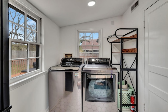 clothes washing area featuring tile patterned flooring and washer and dryer