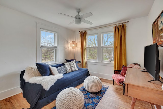 living room featuring ceiling fan, plenty of natural light, and light hardwood / wood-style floors