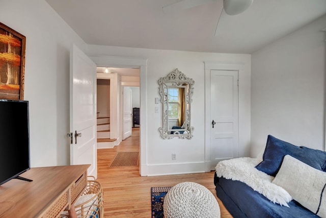 sitting room with ceiling fan and light wood-type flooring