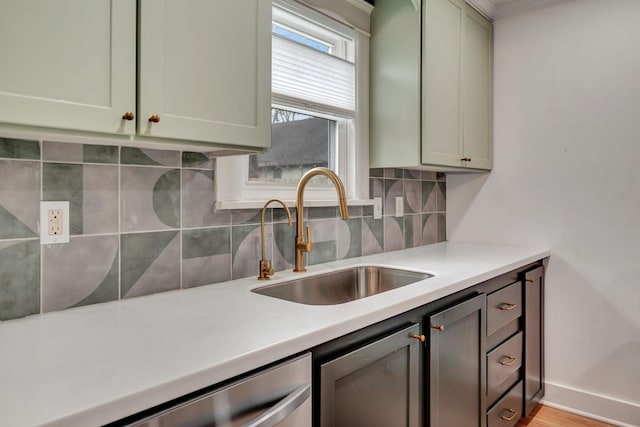 kitchen featuring green cabinets, dishwasher, sink, and decorative backsplash