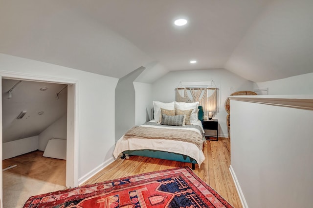 bedroom featuring light hardwood / wood-style floors and vaulted ceiling