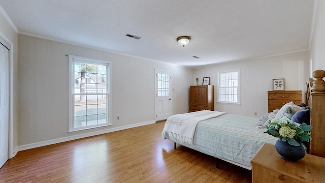 bedroom featuring ornamental molding, hardwood / wood-style floors, and a textured ceiling