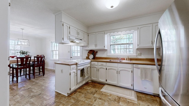 kitchen featuring white cabinetry, white appliances, decorative light fixtures, and kitchen peninsula