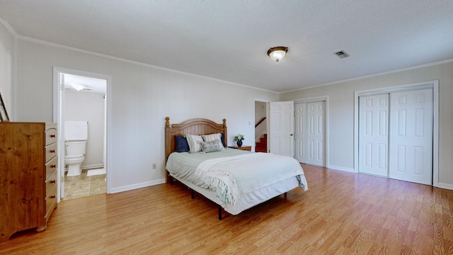 bedroom with multiple closets, ornamental molding, and connected bathroom