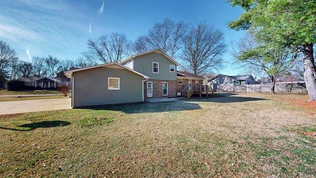 rear view of property featuring a wooden deck and a yard