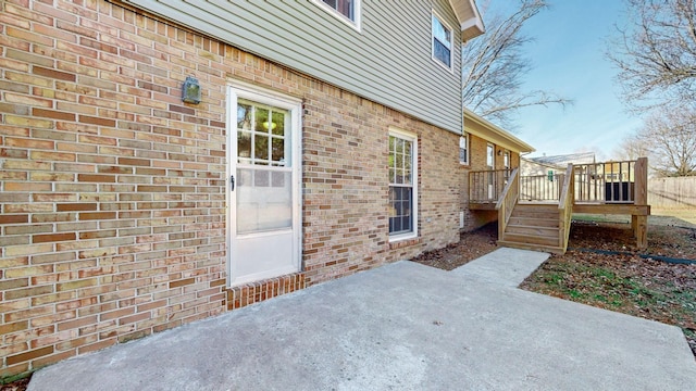 view of side of property featuring a deck and a patio area