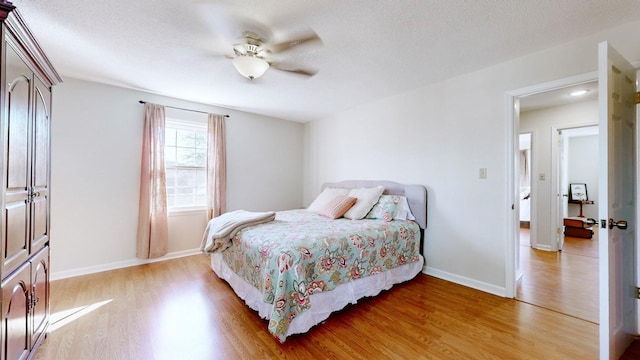 bedroom featuring hardwood / wood-style floors, a textured ceiling, and ceiling fan