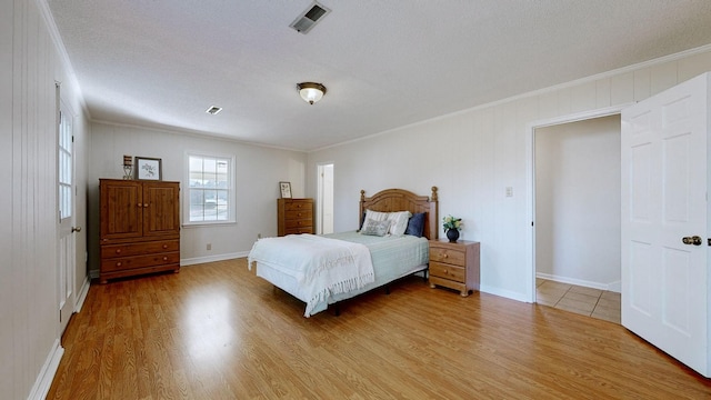 bedroom with ornamental molding, hardwood / wood-style floors, and a textured ceiling