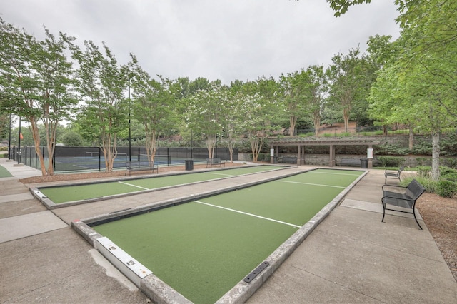 view of home's community featuring tennis court