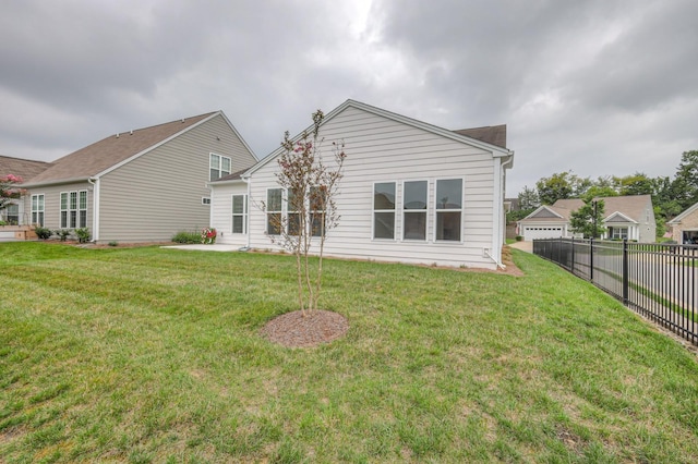 rear view of property with a yard and a patio area