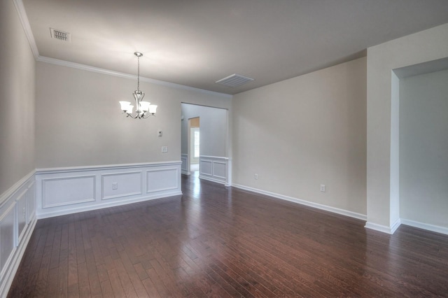 empty room with crown molding, dark hardwood / wood-style flooring, and a notable chandelier