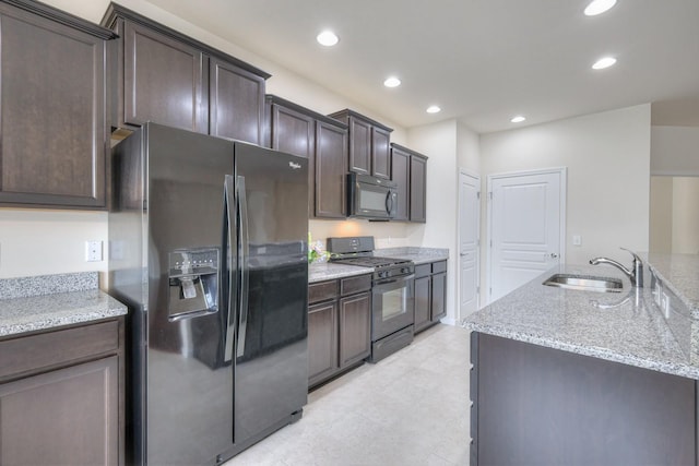 kitchen featuring light stone countertops, sink, dark brown cabinetry, and black appliances