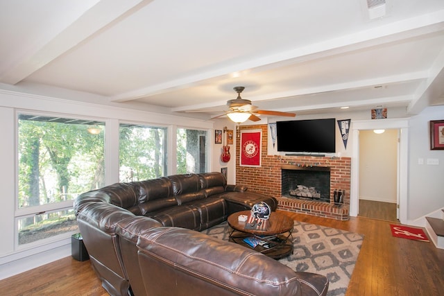 living room featuring ceiling fan, hardwood / wood-style floors, a fireplace, and beam ceiling