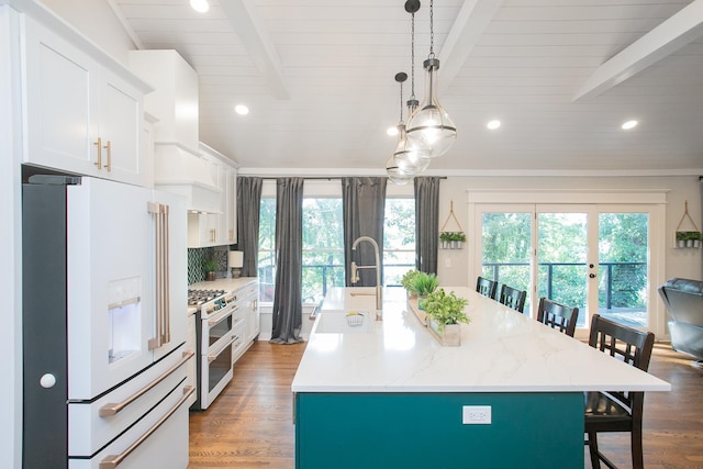 kitchen with an island with sink, a breakfast bar area, and white appliances