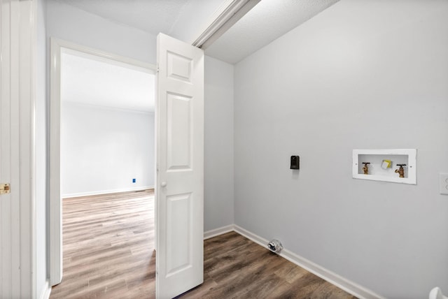 washroom with wood-type flooring, hookup for a gas dryer, hookup for a washing machine, and a textured ceiling