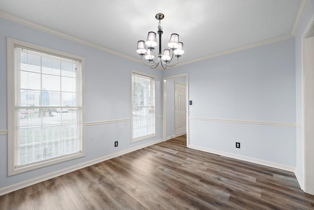 unfurnished dining area featuring ornamental molding, dark hardwood / wood-style flooring, a wealth of natural light, and an inviting chandelier