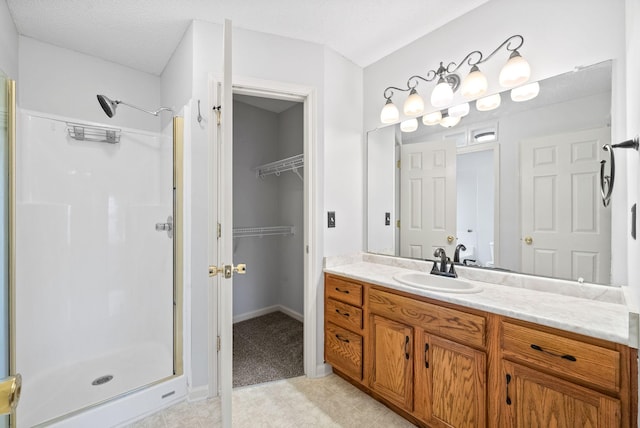 bathroom featuring vanity, a shower with shower door, and a textured ceiling