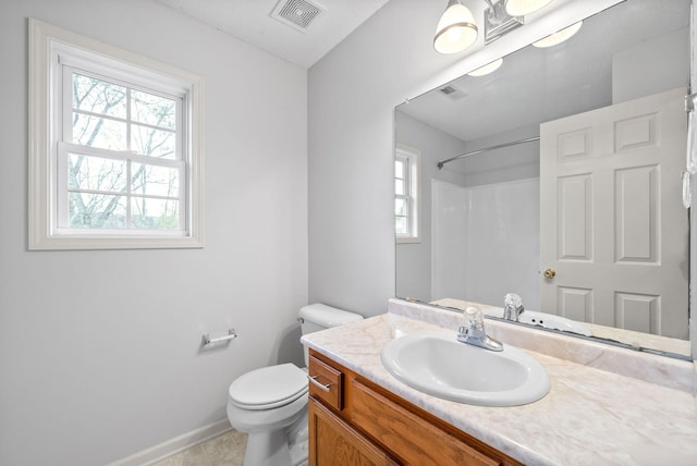 bathroom with tile patterned flooring, vanity, walk in shower, and toilet