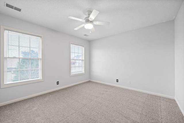 carpeted spare room featuring a textured ceiling and ceiling fan