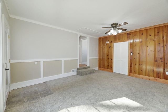 carpeted spare room featuring crown molding and ceiling fan