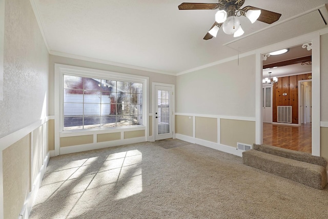 unfurnished room with crown molding, wooden walls, ceiling fan, and carpet flooring