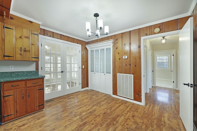 kitchen featuring crown molding, hanging light fixtures, a notable chandelier, french doors, and light wood-type flooring