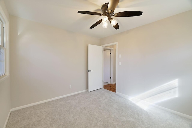 unfurnished room with light colored carpet and ceiling fan