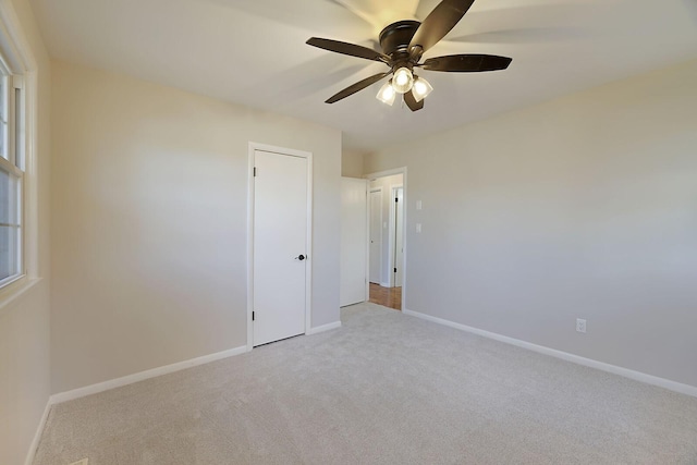 unfurnished room featuring ceiling fan and light carpet