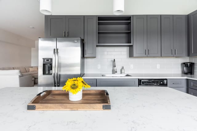 kitchen with tasteful backsplash, sink, stainless steel fridge, and gray cabinetry