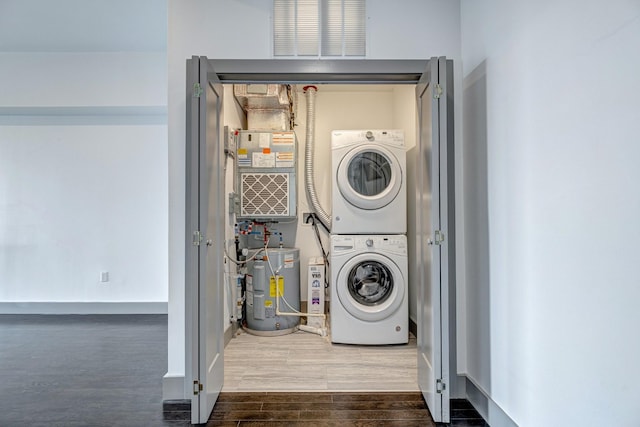 washroom featuring hardwood / wood-style flooring, stacked washer / drying machine, electric water heater, and heating unit