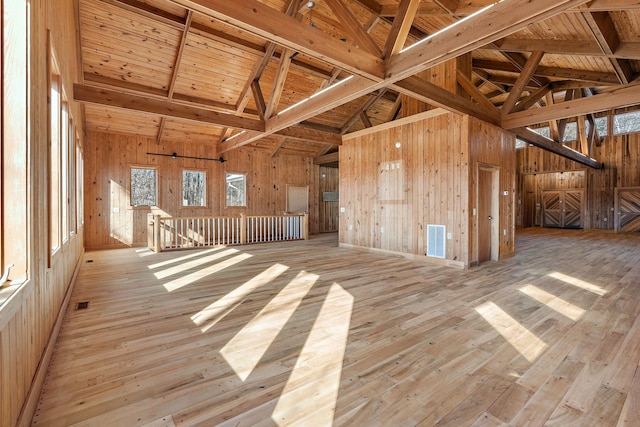 spare room with beam ceiling, wood ceiling, and light hardwood / wood-style flooring