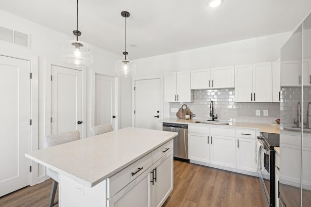 kitchen with white cabinetry, appliances with stainless steel finishes, sink, and a kitchen island