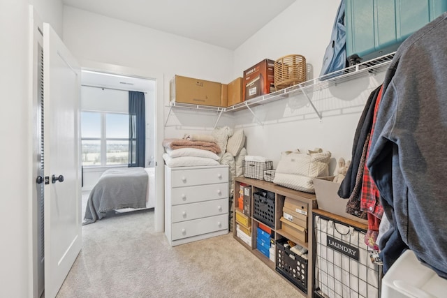 walk in closet featuring light carpet