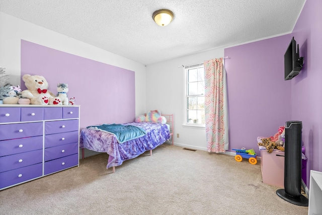 bedroom with light colored carpet and a textured ceiling