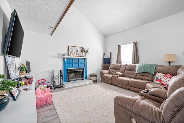 living room with light hardwood / wood-style flooring, vaulted ceiling, and a textured ceiling