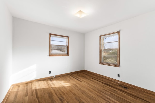 unfurnished room featuring hardwood / wood-style flooring and a healthy amount of sunlight